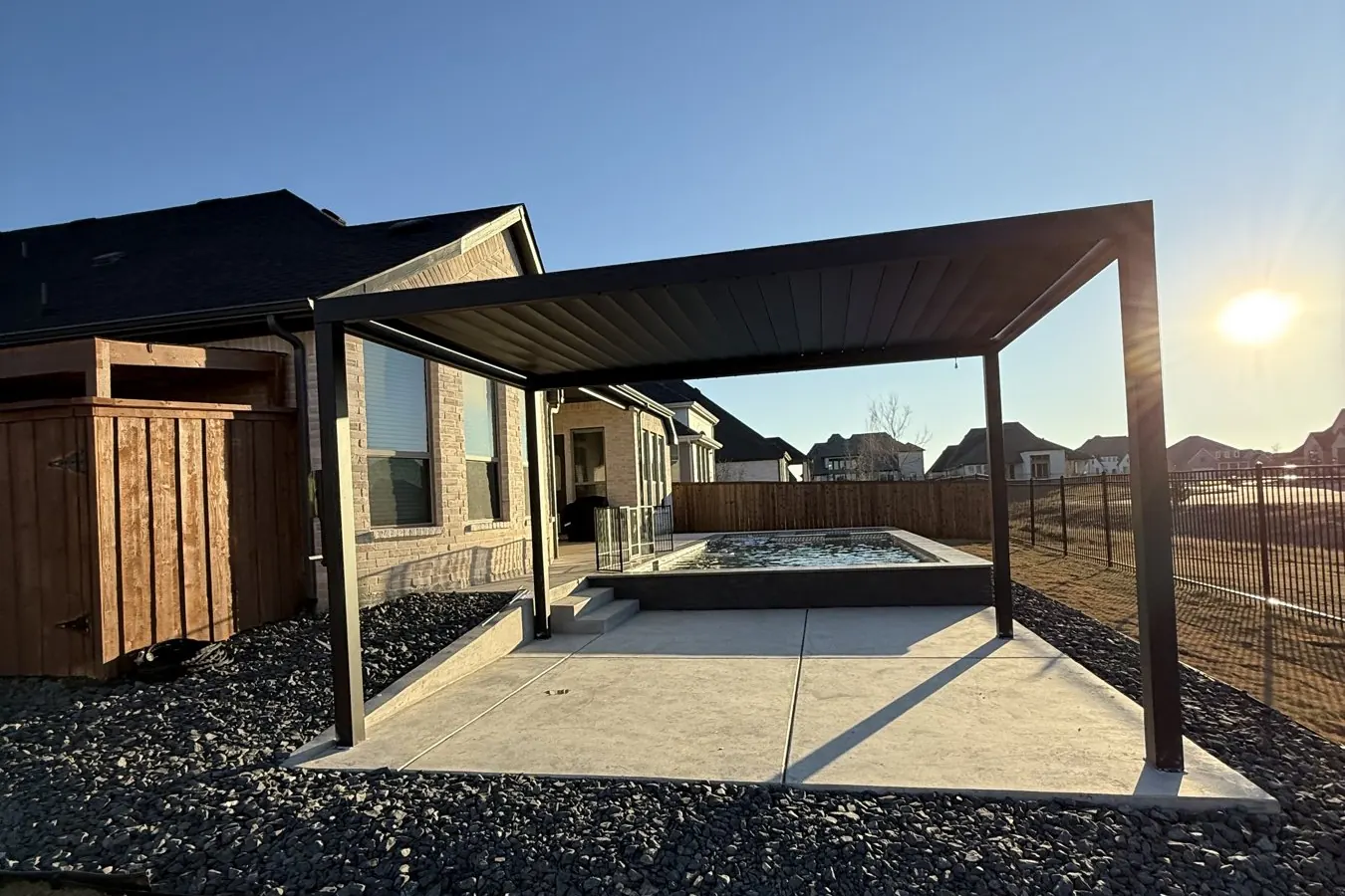 Concrete patio with a pergola in a new build backyard