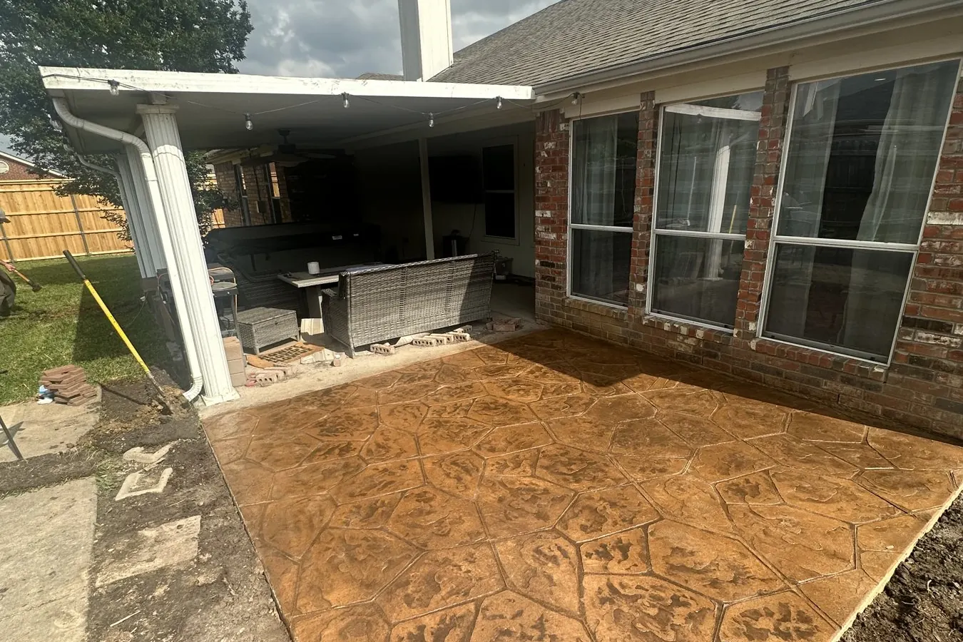 Stamped and stained concrete patio behind a brick home in Frisco, TX