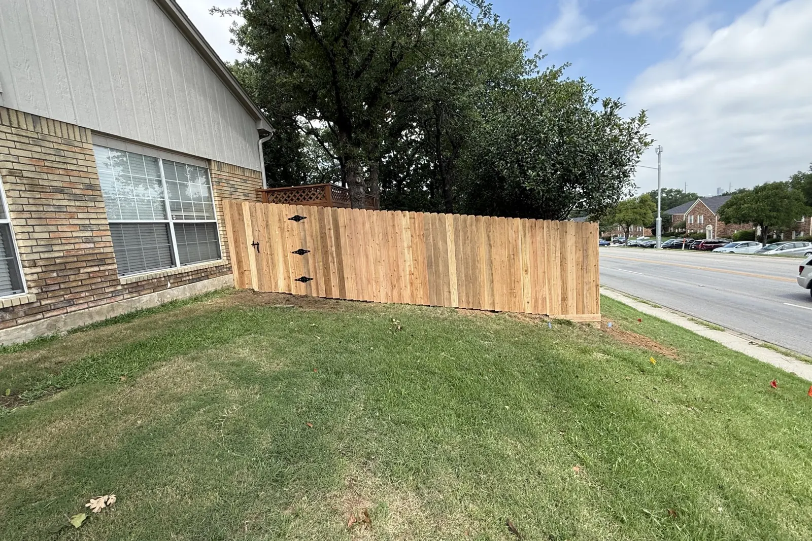 Cedar privacy fence with double gate along a street in McKinney