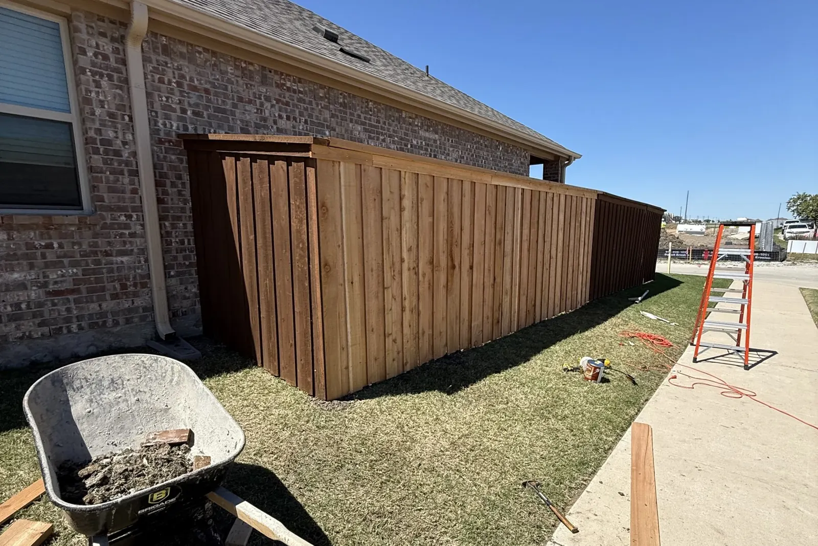 Fence installation in progress, pickets going up