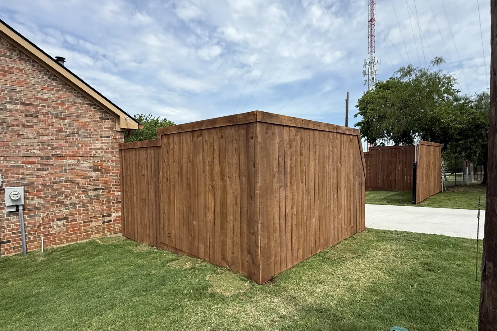 Stained cedar fence along a driveway in Prosper