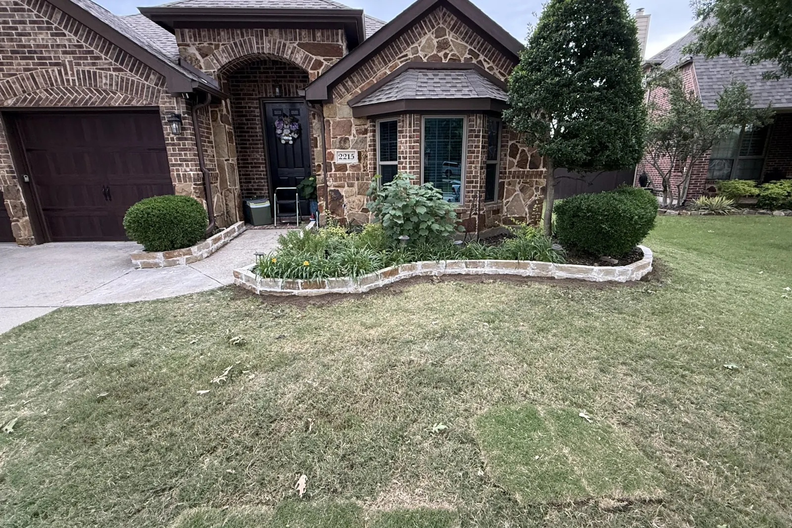 Stone flowerbed border around a front yard tree